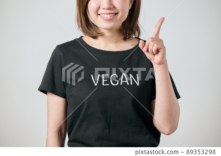 一位穿著純素 T 卹並用食指指著的年輕女子 89353298