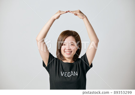 一位身穿純素 T 卹並擺出 Maru 姿勢的年輕女子 89353299