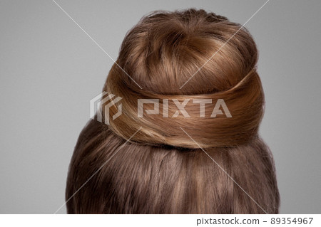 Back side view closeup portrait with creative elegant brown collected hairstyle, bun hair. indoor studio shot, isolated on grey background. 89354967