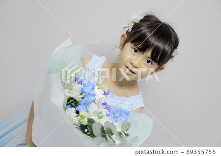 Elementary school girl wearing a dress and a bouquet (7 years old) 89355758