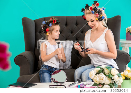 Mom and daughter in the studio on the sofa in the curlers make up and have fun Mom and daughter in the studio on the sofa in the curlers make up and have fun 89358014