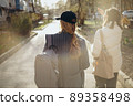 Back view portrait of two women walking and talking in a park asunny day 89358498