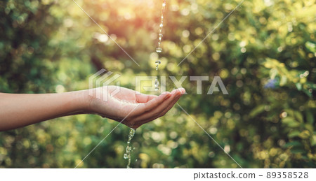 Water pouring on hand in morning ligth background. Water pouring on hand in morning ligth background. 89358528