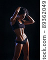 Female fitness model posing on black background 89362049