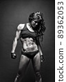 Female fitness model posing on black background 89362053