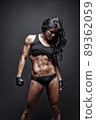 Female fitness model posing on black background 89362059
