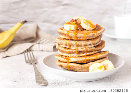Wholegrain pancakes with banana and caramel sauce. Delicious breakfast. 89362136