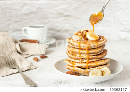 Wholegrain pancakes with banana and caramel sauce. Delicious breakfast. 89362137