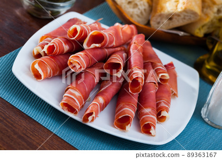 Traditional Spanish meal - rolls of iberian jamon served at plate Traditional Spanish meal - rolls of iberian jamon served at plate 89363167