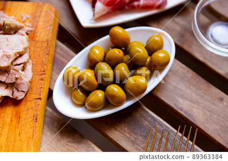 Pile of green olives served on table Pile of green olives served on table 89363384