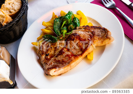 Beef steak with French fries and baked jalapenos Beef steak with French fries and baked jalapenos 89363385
