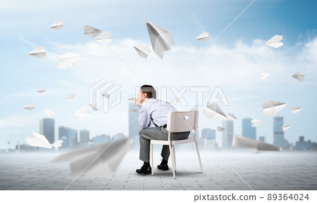 Young businessman sitting on an office chair Young businessman sitting on an office chair 89364024