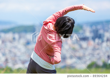 Japanese middle-aged woman exercising outdoors Japanese middle-aged woman exercising outdoors 89364284