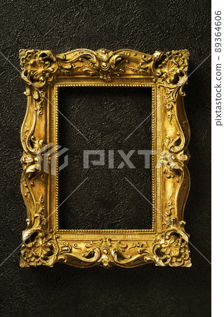 Golden antique picture frame hung on a black wall Golden antique picture frame hung on a black wall 89364606