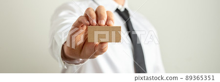 Businessman holding blank wooden peg towards the camera Businessman holding blank wooden peg towards the camera 89365351