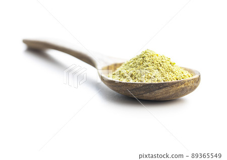 Ground green coffee in wooden spoon. Unroasted coffee isolated on white background. 89365549