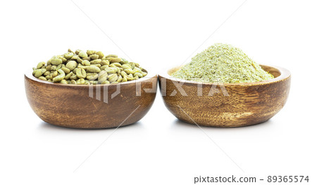 Ground green coffee and coffee beans in wooden bowl. Unroasted coffee isolated on white background. 89365574