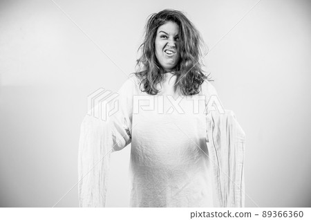 Close-up portrait of insane woman in straitjacket on white background. Monochrome. 89366360