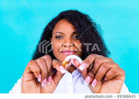 afro woman winning with addicted nicotine problems, stop smoking studio blue background 89366645