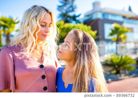 Smiling mother and beautiful daughter having fun on the beach 89366732
