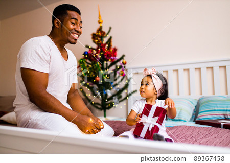 happy mixed race dad and beautiful child in the merry x-mas morning in bedroom happy mixed race dad and beautiful child in the merry x-mas morning in bedroom 89367458