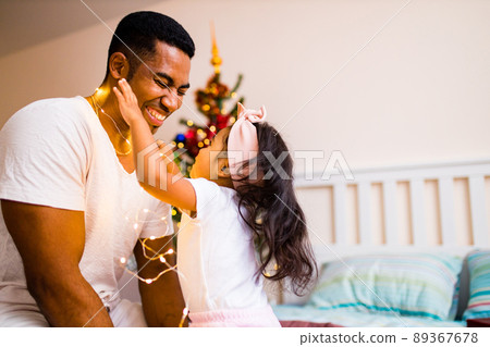happy mixed race dad and beautiful child in the merry x-mas morning in bedroom happy mixed race dad and beautiful child in the merry x-mas morning in bedroom 89367678
