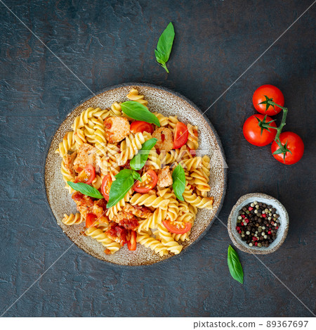 fusilli pasta with tomato sauce, chicken fillet with basil leaves fusilli pasta with tomato sauce, chicken fillet with basil leaves 89367697