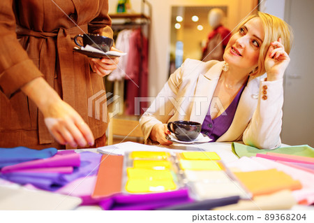 color scheme, decoration, design and people concept - smiling young woman with color swatches or samples helping to choice cloths 89368204