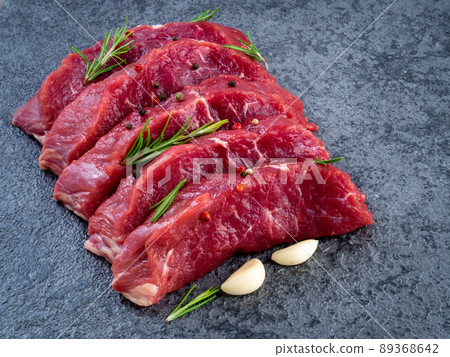 Raw meat, beef steak with seasoning on a black stone table, side view 89368642