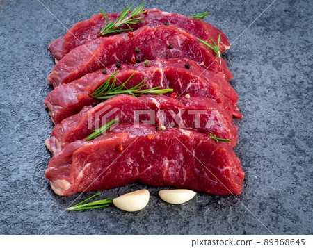 Raw meat, beef steak with seasoning on a black stone table, side view 89368645