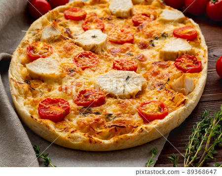 Appetizing golden focaccia with tomatoes, chiken meat, spices on dark wooden rustic table Appetizing golden focaccia with tomatoes, chiken meat, spices on dark wooden rustic table 89368647