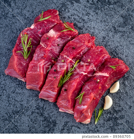 Raw meat, beef steak with seasoning on black stone table, top view Raw meat, beef steak with seasoning on black stone table, top view 89368705