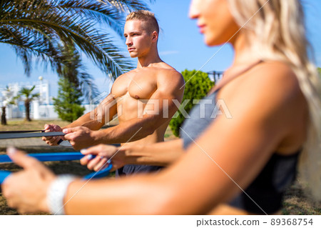 Young couple in sports outfit doing morning workout outdoors in hot summer Young couple in sports outfit doing morning workout outdoors in hot summer 89368754