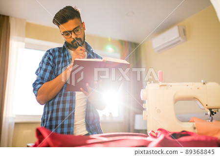 indian man sewing new collection in showroom in living room 89368845