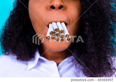 afro woman winning with addicted nicotine problems, stop smoking studio blue background 89368997