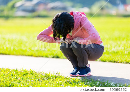Japanese middle-aged woman exercising in an outdoor park Japanese middle-aged woman exercising in an outdoor park 89369262