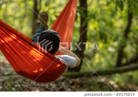 Relaxing in hammock in tropical forest Relaxing in hammock in tropical forest 89370854