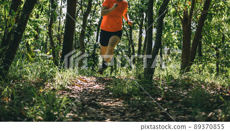 Woman runner running on forest trail Woman runner running on forest trail 89370855