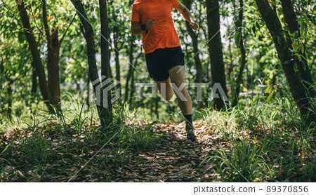 Woman runner running on forest trail Woman runner running on forest trail 89370856