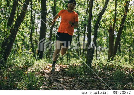 Woman runner running on forest trail Woman runner running on forest trail 89370857