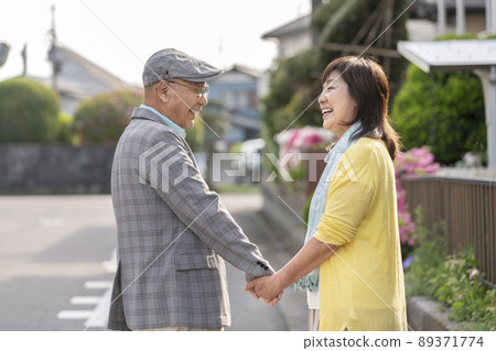 老夫婦手牽手,面帶微笑地凝視著對方 老夫婦手牽手,面帶微笑地凝視著對方 89371774