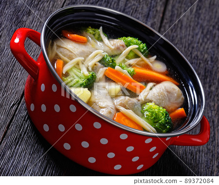 chicken vegetable soup with pasta in red pot chicken vegetable soup with pasta in red pot 89372084