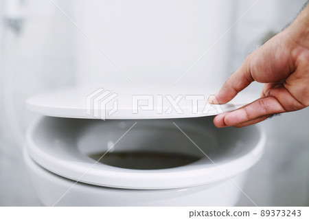 man's hand opening the toilet lid man's hand opening the toilet lid 89373243