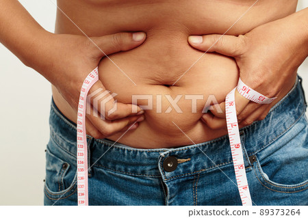 fat man check out body overweight abdomen his belly with in hand measuring tape fat man check out body overweight abdomen his belly with in hand measuring tape 89373264