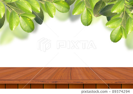 Empty wooden table with green leaves on white background for product advertising. Empty wooden table with green leaves on white background for product advertising. 89374294
