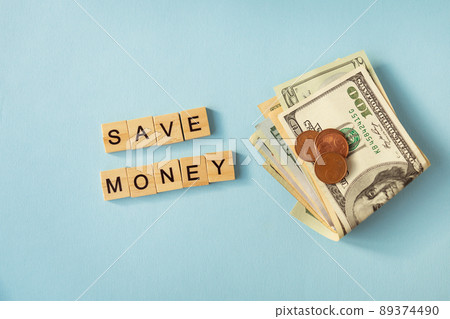 Money in international currency, dollars, euro coins lie on a blue background. Lettering save money. 89374490