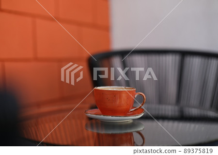 a cup of coffee on glass table in the morning a cup of coffee on glass table in the morning 89375819
