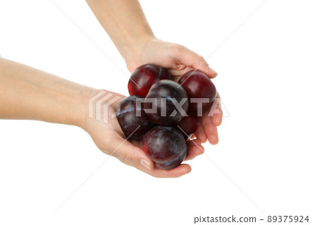 A handful of plums in female hands, isolated on white background A handful of plums in female hands, isolated on white background 89375924