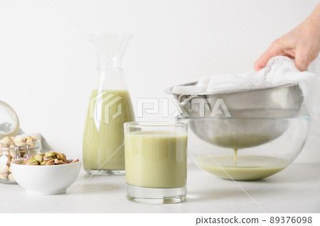 Pistachio milk in glass, lactose free. Vegan alternative plant based milk. Pistachio milk in glass, lactose free. Vegan alternative plant based milk. 89376098