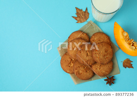 Milk and pumpkin cookies on blue background Milk and pumpkin cookies on blue background 89377236